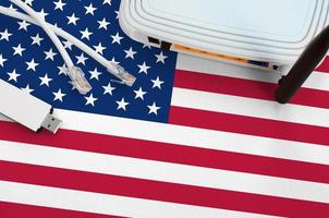 United States of America flag depicted on table with internet rj45 cable, wireless usb wifi adapter and router. Internet connection concept photo