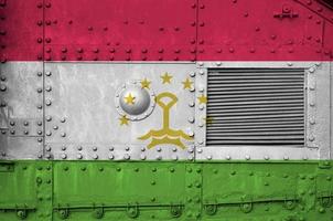 Tajikistan flag depicted on side part of military armored tank closeup. Army forces conceptual background photo