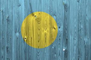 Palau flag depicted in bright paint colors on old wooden wall. Textured banner on rough background photo