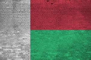 Madagascar flag depicted in paint colors on old brick wall. Textured banner on big brick wall masonry background photo