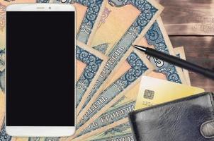 5 Ukrainian hryvnias bills and smartphone with purse and credit card. E-payments or e-commerce concept. Online shopping and business with portable devices photo