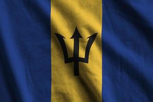 Barbados flag with big folds waving close up under the studio light indoors. The official symbols and colors in banner photo