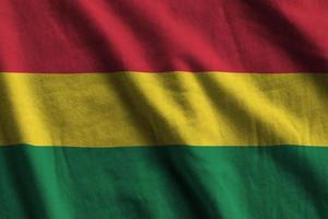 Bolivia flag with big folds waving close up under the studio light indoors. The official symbols and colors in banner photo