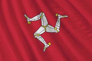 Isle of Man flag with big folds waving close up under the studio light indoors. The official symbols and colors in banner photo