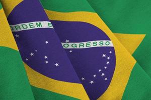 Brazil flag with big folds waving close up under the studio light indoors. The official symbols and colors in banner photo