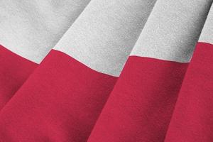 Poland flag with big folds waving close up under the studio light indoors. The official symbols and colors in banner photo