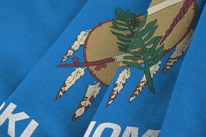 Oklahoma US state flag with big folds waving close up under the studio light indoors. The official symbols and colors in banner photo