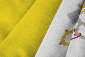 Vatican City State flag with big folds waving close up under the studio light indoors. The official symbols and colors in banner photo