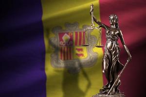 Andorra flag with statue of lady justice and judicial scales in dark room. Concept of judgement and punishment photo