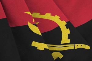 Angola flag with big folds waving close up under the studio light indoors. The official symbols and colors in banner photo