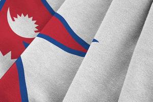 Nepal flag with big folds waving close up under the studio light indoors. The official symbols and colors in banner photo