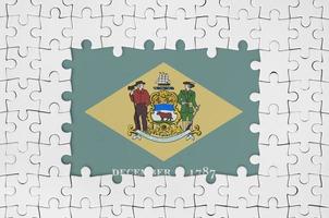 Delaware US state flag in frame of white puzzle pieces with missing central part photo