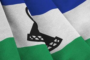 Lesotho flag with big folds waving close up under the studio light indoors. The official symbols and colors in banner photo