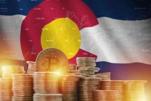 Colorado US state flag and big amount of golden bitcoin coins and trading platform chart. Crypto currency photo