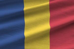bandera de rumania con grandes pliegues ondeando de cerca bajo la luz del estudio en el interior. los símbolos y colores oficiales en banner foto