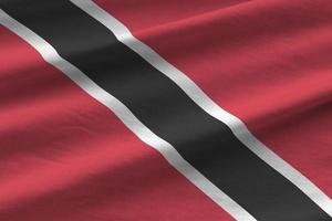 Trinidad and Tobago flag with big folds waving close up under the studio light indoors. The official symbols and colors in banner photo