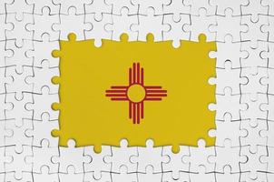 New Mexico US state flag in frame of white puzzle pieces with missing central part photo