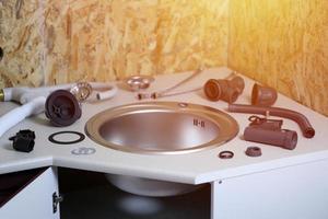 Tools and water tap ready for installation sink on countertop photo