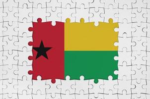 Guinea Bissau flag in frame of white puzzle pieces with missing central part photo