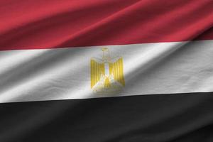 Egypt flag with big folds waving close up under the studio light indoors. The official symbols and colors in banner photo