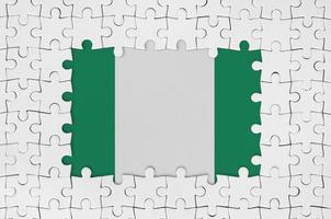bandera de nigeria en el marco de piezas de un rompecabezas blanco con la parte central faltante foto