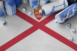 Jersey flag and few used aerosol spray cans for graffiti painting. Street art culture concept photo