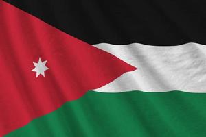 bandera jordana con grandes pliegues ondeando de cerca bajo la luz del estudio en el interior. los símbolos y colores oficiales en banner foto