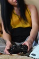 A young girl plays video games with a black joystick with many b photo