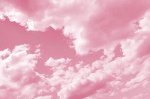 A blue sky with lots of white clouds of different sizes Image toned in Viva Magenta, color of the year photo