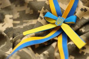 Military camouflage fabric with ukrainian stripes on ribbon photo