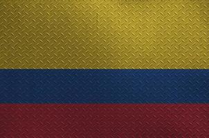 Colombia flag depicted in paint colors on old brushed metal plate or wall closeup. Textured banner on rough background photo