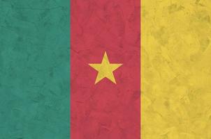 bandera de camerún representada en colores de pintura brillante en la antigua pared de yeso en relieve. banner texturizado sobre fondo áspero foto