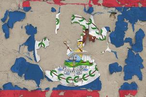 Belize flag depicted in paint colors on old obsolete messy concrete wall closeup. Textured banner on rough background photo