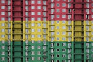 Bolivia flag depicted in paint colors on multi-storey residental building under construction. Textured banner on brick wall background photo