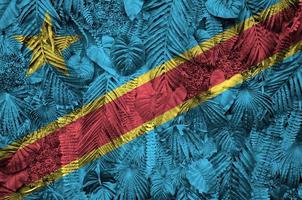 Democratic Republic of the Congo flag depicted on many leafs of monstera palm trees. Trendy fashionable backdrop photo