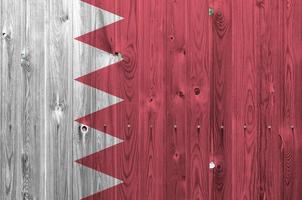 Bahrain flag depicted in bright paint colors on old wooden wall. Textured banner on rough background photo