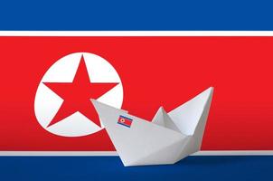 North Korea flag depicted on paper origami ship closeup. Handmade arts concept photo
