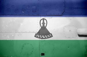 Lesotho flag depicted on side part of military armored helicopter closeup. Army forces aircraft conceptual background photo