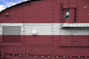 Latvia flag depicted on side part of military armored tank closeup. Army forces conceptual background photo