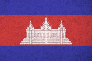 Cambodia flag depicted in bright paint colors on old relief plastering wall. Textured banner on rough background photo