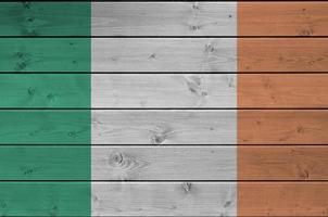 Ireland flag depicted in bright paint colors on old wooden wall. Textured banner on rough background photo