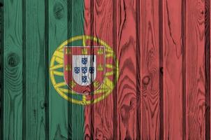 Portugal flag depicted in bright paint colors on old wooden wall. Textured banner on rough background photo