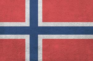 Norway flag depicted in bright paint colors on old relief plastering wall. Textured banner on rough background photo