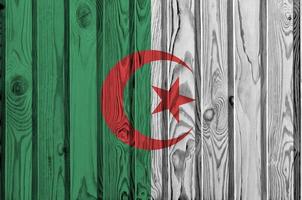 bandera de argelia representada en colores de pintura brillante en una pared de madera vieja. banner texturizado sobre fondo áspero foto