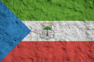 Equatorial Guinea flag depicted in bright paint colors on old relief plastering wall. Textured banner on rough background photo