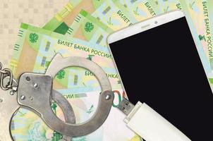 200 russian rubles bills and smartphone with police handcuffs. Concept of hackers phishing attacks, illegal scam or malware soft distribution photo