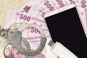 500 Hungarian forint bills and smartphone with police handcuffs. Concept of hackers phishing attacks, illegal scam or malware soft distribution photo