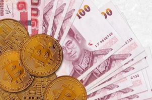 100 Thai Baht bills and golden bitcoins. Cryptocurrency investment concept. Crypto mining or trading photo