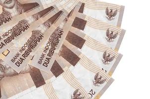 Los billetes de 2000 rupias indonesias se encuentran aislados en fondo blanco con espacio de copia apilado en forma de abanico de cerca foto
