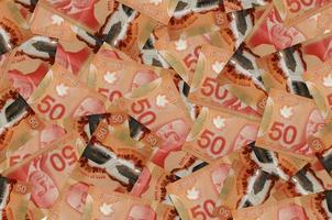 50 Canadian dollars bills lies in big pile. Rich life conceptual background photo